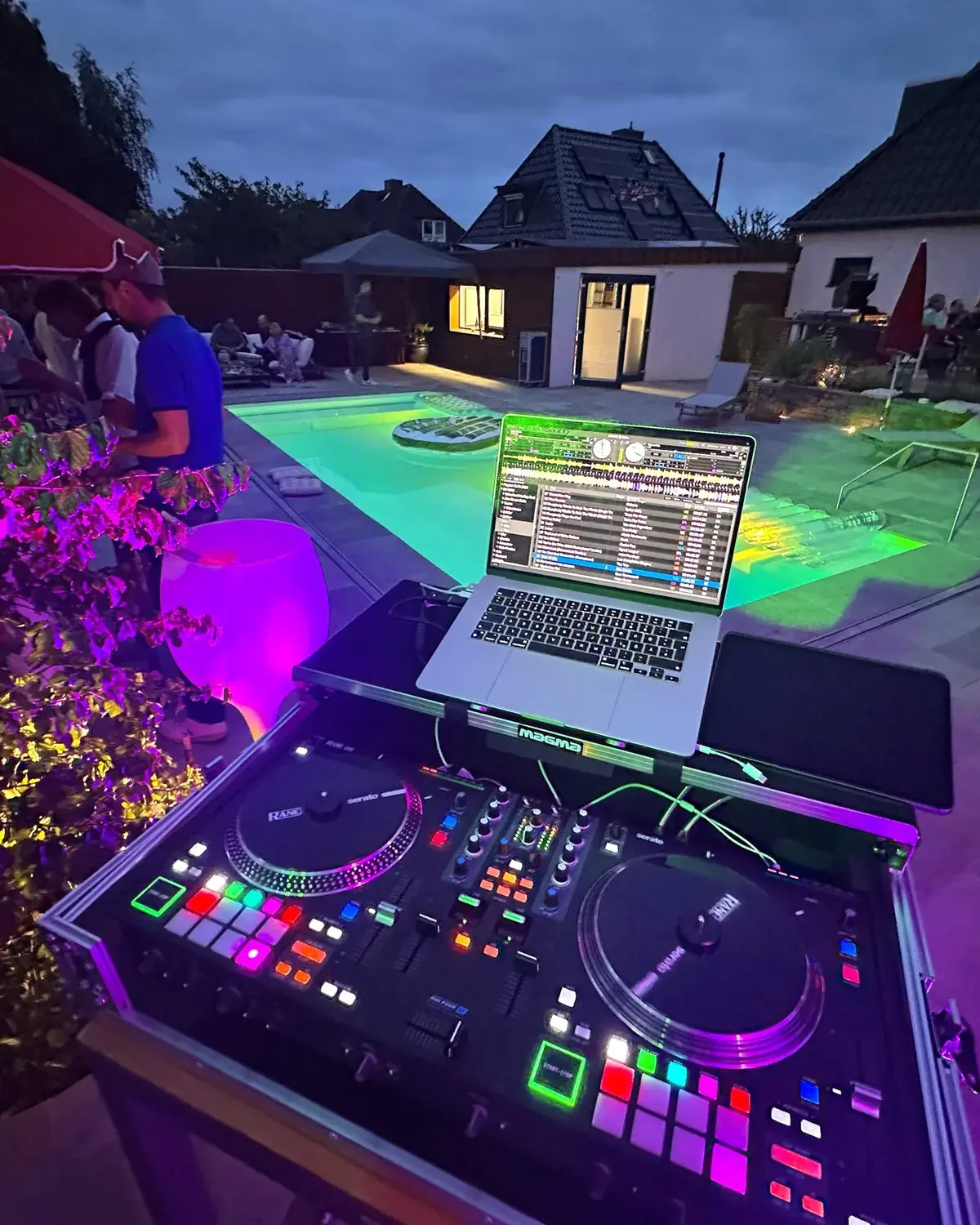 Poolparty am Abend mit DJ-Setup und Lichtstimmung