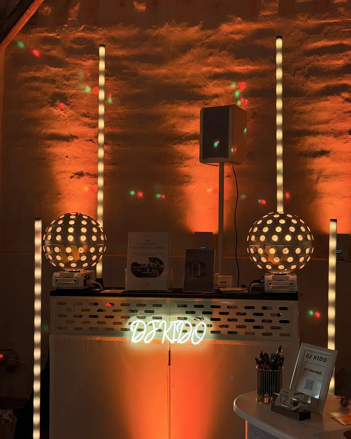 DJ-Setup mit warmem Ambientelicht und Diskokugeln