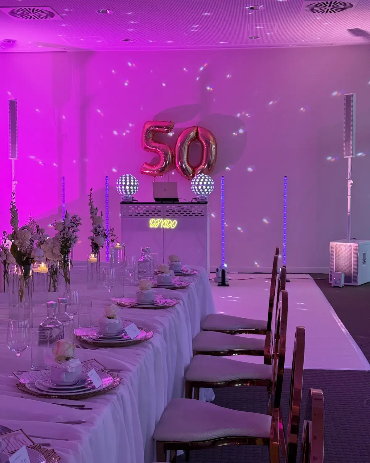 Festlich gedeckte Tafel mit pinker Lichtstimmung