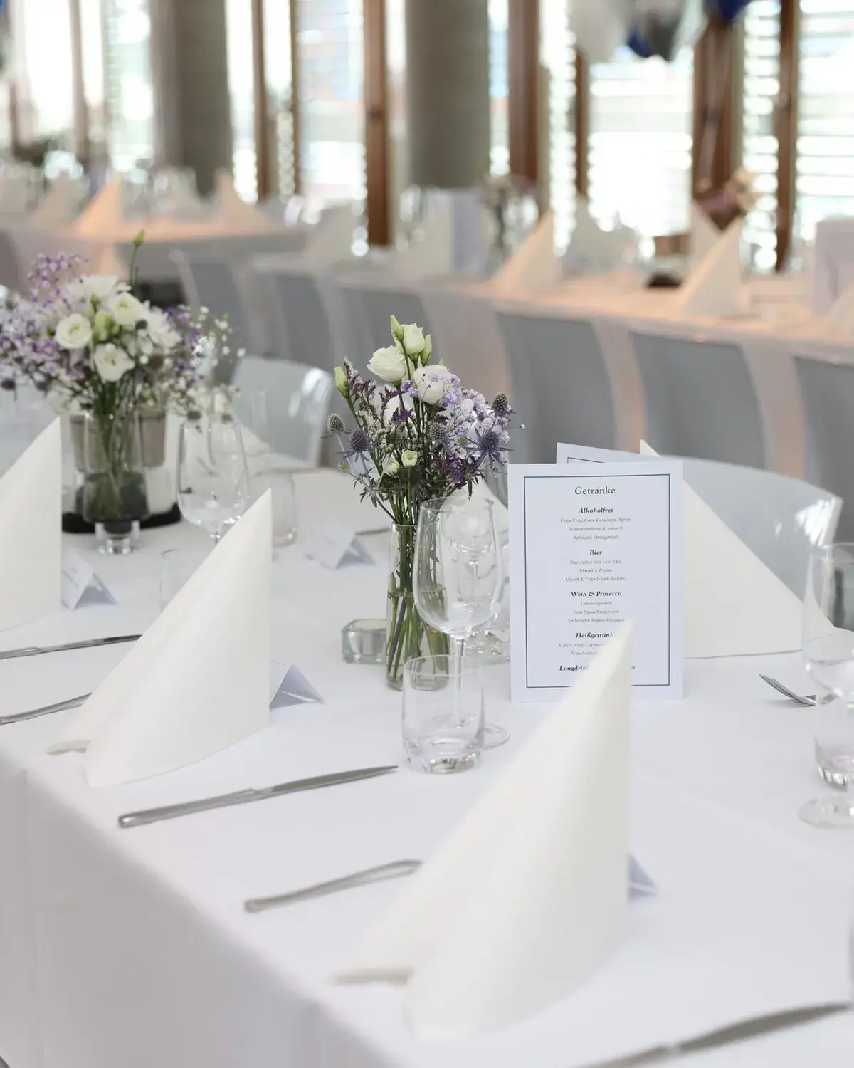 Hochzeitstafel mit weisser Deko und Blumen