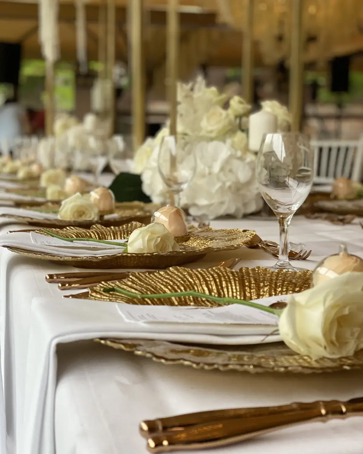 Hochzeitstisch mit goldener Deko und weissen Rosen