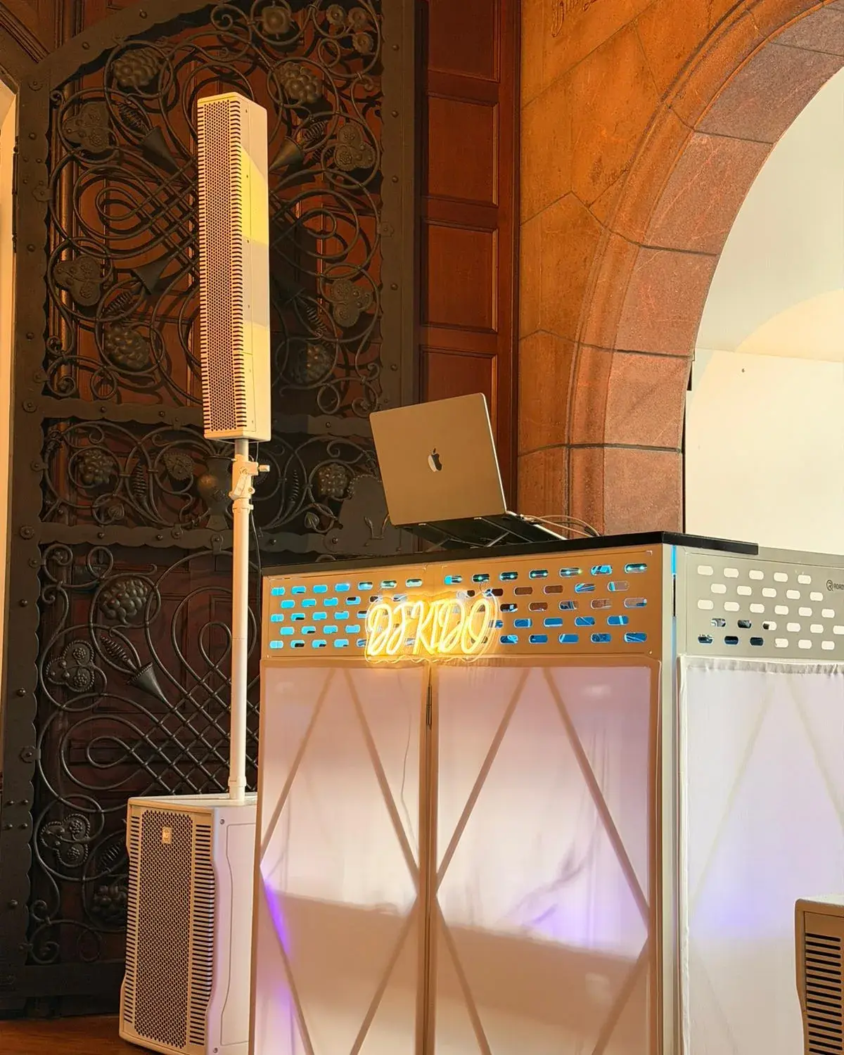 Weiße DJ-Booth mit Neon-Schriftzug in einem historischen Gewölbe