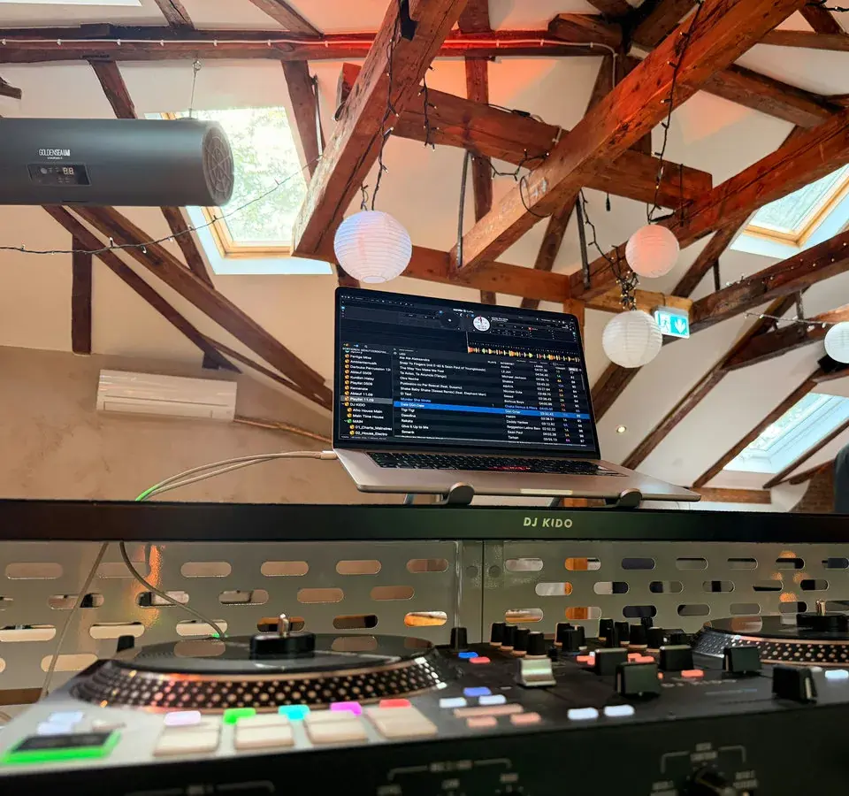 DJ-Pult von DJ Kido unter dem offenen Dachstuhl der Eppendorfer Insel mit Lampions und Lichterketten