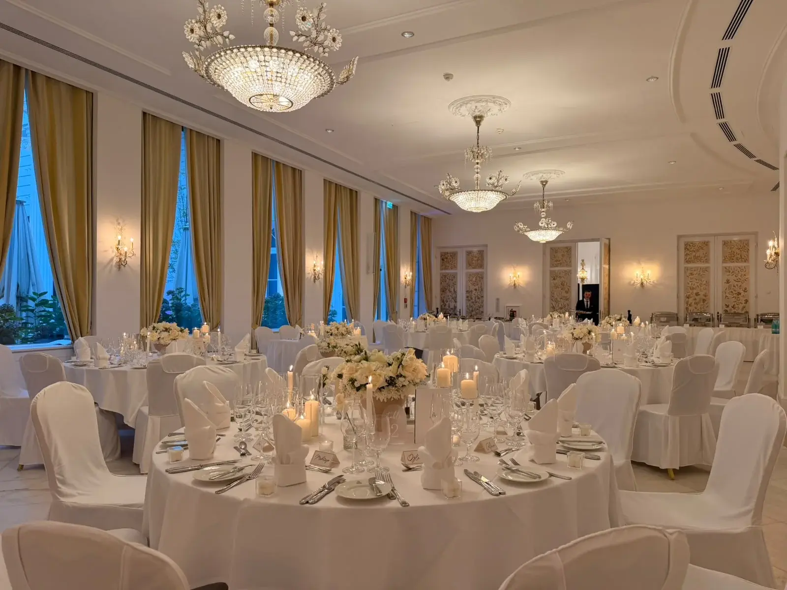 Großer Festsaal im Hotel Atlantic Hamburg mit runden Tafeln, weißen Blumen und Kristallleuchtern