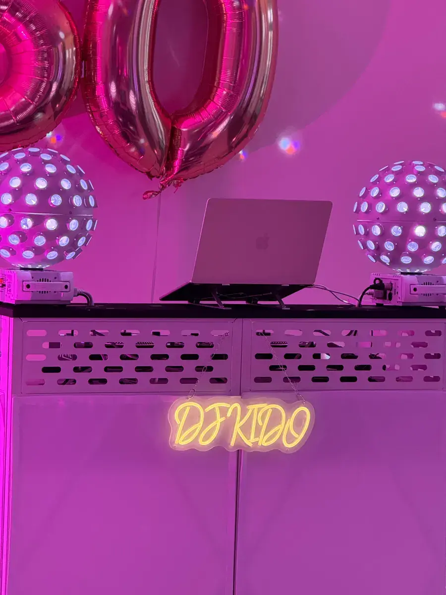 DJ Kido hinter seiner weißen Booth beim 50. Geburtstag im IntercityHotel Hamburg-Barmbek, mit DJ-KIDO-Neon und violettem Partylicht