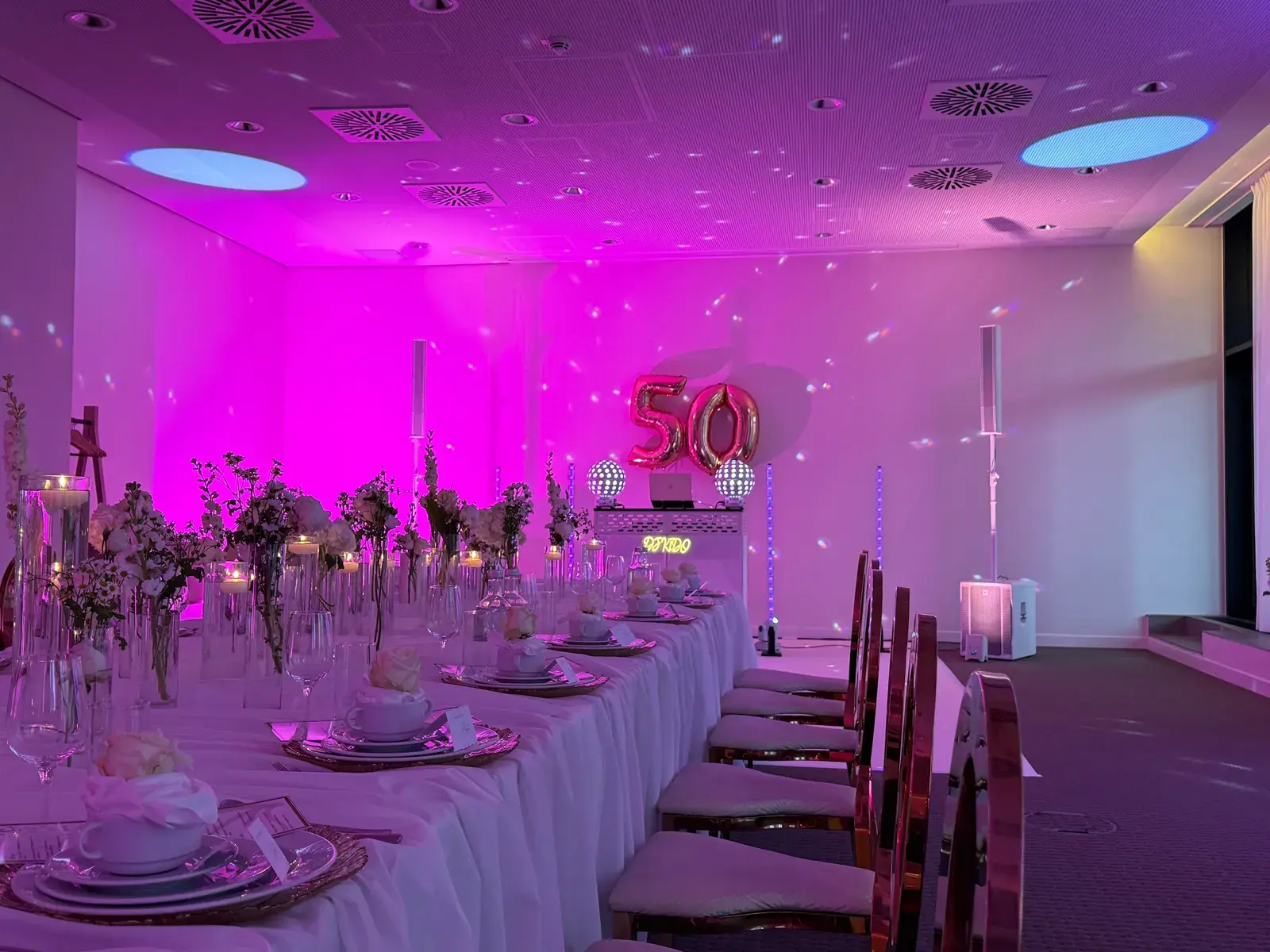 DJ-KIDO-Setup mit weißer Booth, Neon-Schriftzug und Lichtsäulen im IntercityHotel Hamburg-Barmbek