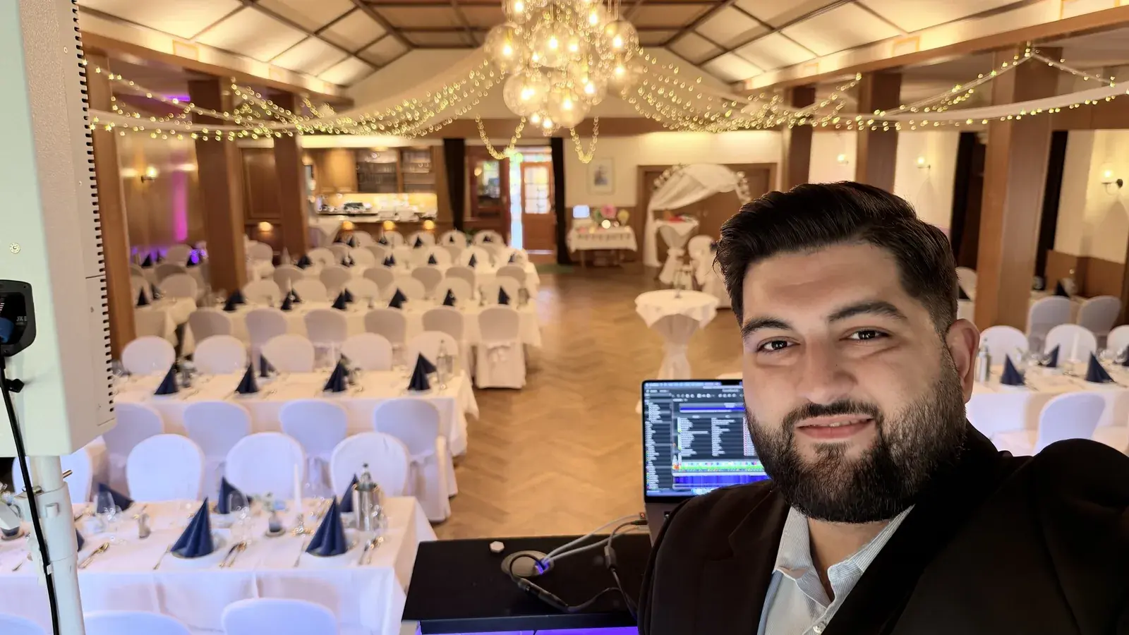 DJ Kido am DJ-Pult vor dem zur Hochzeit geschmückten Festsaal im Landhotel Zur Eiche