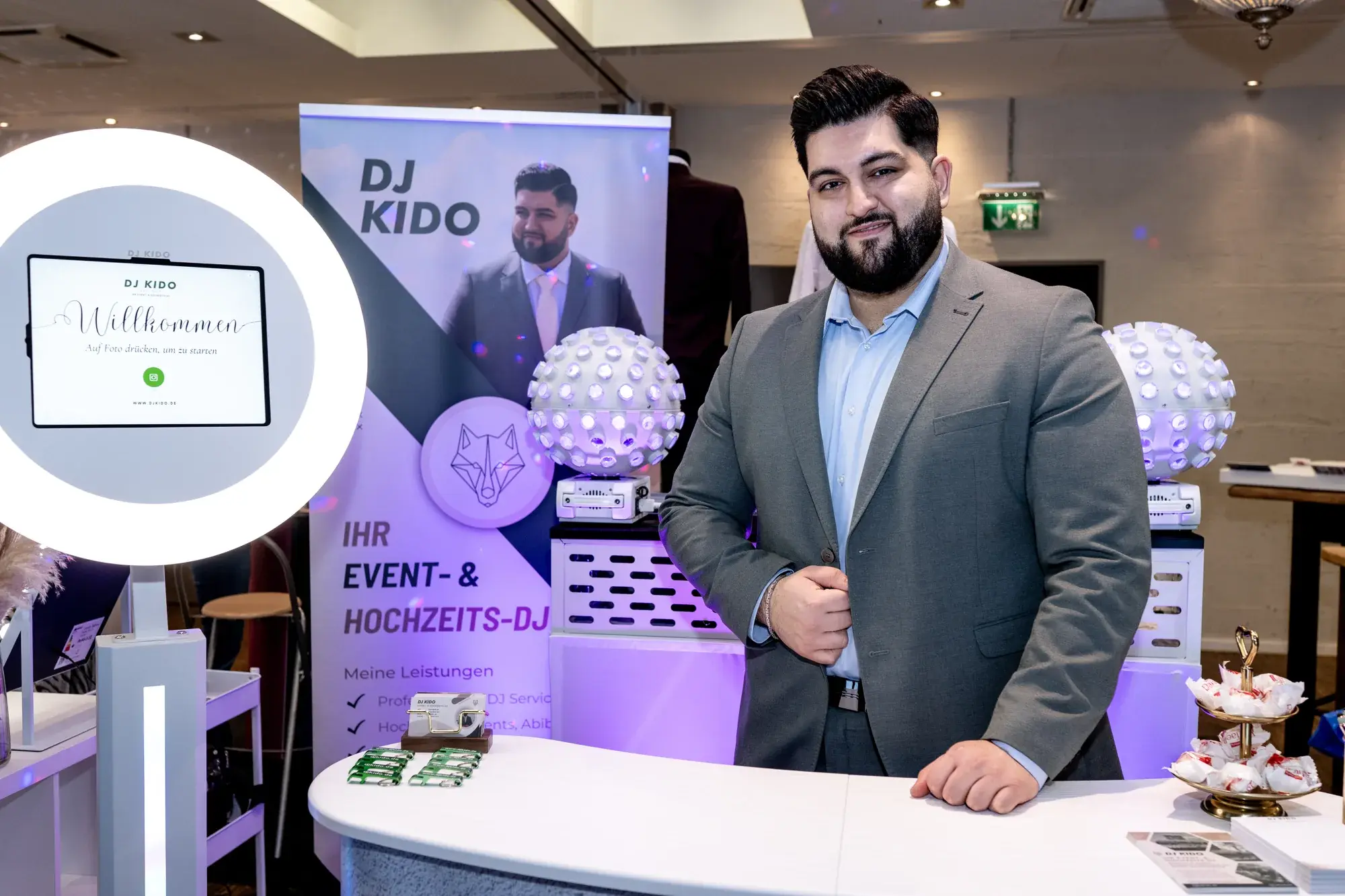 Ali Biabani, DJ Kido, im grauen Sakko an seinem Stand auf der Sag JA in Neumünster